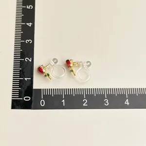 Detail view of vintage burgundy rose clip-on earrings with gold plating and transparent cushion.