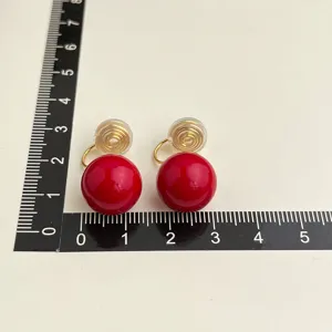 Red ball clip-on earrings with gold-tone coil screw back design, size display shot.