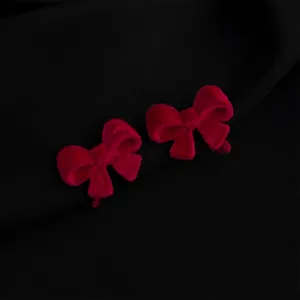 Red velvet bow earrings detail shot, elegant retro style jewelry accessory for women, chic design.