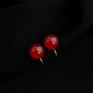 Close-up of wine red round clip-on earrings, vintage gold plated non-pierced design detail.