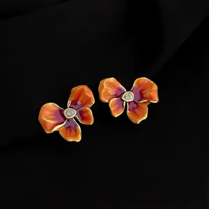 Detail shot of vintage style gradient orange enamel flower clip-on earrings with crystal center.