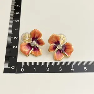 Vintage enamel flower clip-on earrings with sparkling crystal center and gold-plated finish.
