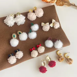 Detailansicht süßer Herbst Winter Plüschball Ohrringe mit Schleifen und flauschigen Texturen.
