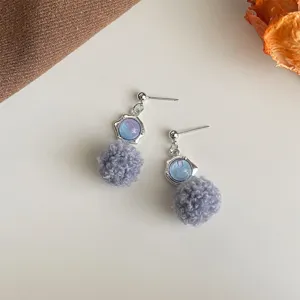 Nahaufnahme süßer Herbst Winter graue Bommel Ohrringe mit blauem Stein Metall.