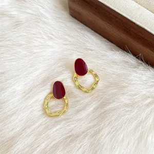 Detailansicht der französischen Retro-Ohrringe mit roter Emaillierung und goldenem Design.