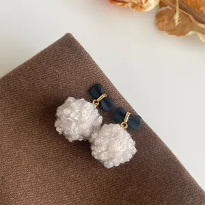 Süße Plüschball Ohrringe mit schwarzer Schleife, ideales Herbst Winter Modeschmuck Detail.
