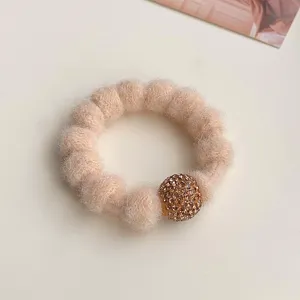 Close-up detail of plush rhinestone hair tie, soft fleece scrunchie with crystal charm