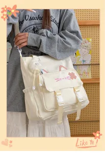 Detail shot of cute cat canvas shoulder bag with plush charm and large capacity for daily use.