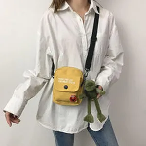 Λεπτομερης οψη casual κιτρινης τσάντας χιαστι καμβά για γυναίκες με χαριτωμένο κρεμαστό.
