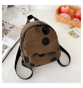 Brown corduroy mini backpack with black polka dots, detailed close-up shot of casual style bag.