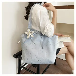 Detail view of light blue star print tote bag with cute silver star pendant for women.