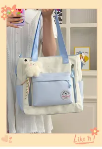 Vue détaillée du sac cabas en toile mignon avec couleurs contrastées et pendentif en peluche.