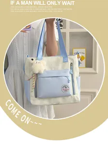 Vue détaillée du sac cabas en toile bicolore avec poche avant et joli pendentif en peluche.