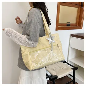 Vista dettagliata di una borsa tote con stampa di stelle e comoda tasca frontale trasparente.