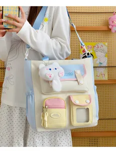 Vista detallada del bolso de lona estilo japonés con múltiples bolsillos y colgante de gato.