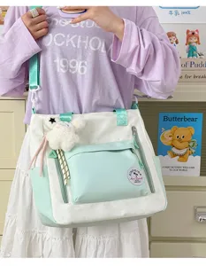 Vue détaillée du sac cabas en toile avec poche vert menthe, charm's d'ourson et bandoulière.