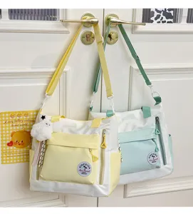 Détail du sac cabas en toile avec poches colorées et charmant pendentif en peluche.