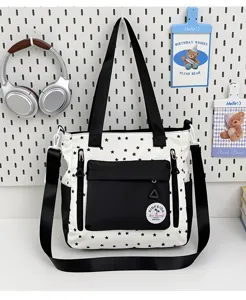 Vue détaillée du sac cabas en toile à motifs d'étoiles avec une poche zippée pratique à l'avant.