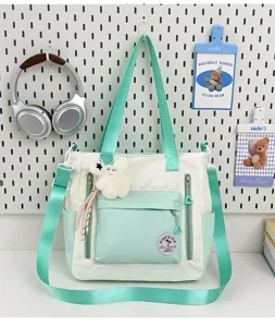 Vue détaillée du sac cabas élégant en toile vert menthe et blanc avec plusieurs poches.