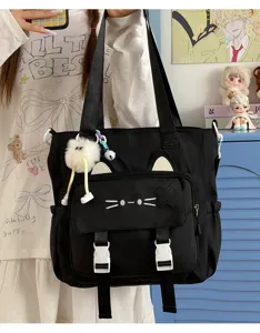 Japanese style black canvas shoulder bag with cute cat ears embroidery and plush doll pendant.