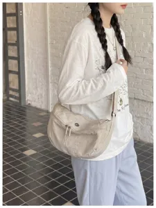 Detail view of the casual nylon crescent shoulder bag worn by model, practical daily wear.