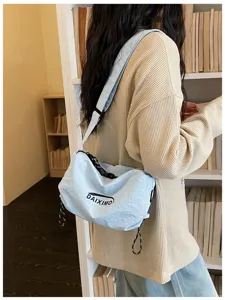 Vista di dettaglio della borsa a tracolla in nylon da donna con stampa di lettere e tracolla.