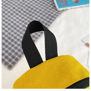 Yellow canvas bag detail with black handle and zipper, casual daily small pouch accessory.