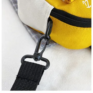 Close-up detail of canvas crossbody bag strap and black metal hardware buckle, casual style.