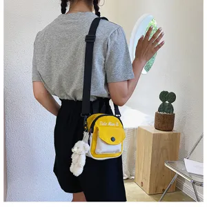 Detail view of stylish canvas crossbody bag for women, featuring cute bear pendant and strap.