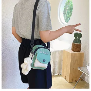 Canvas crossbody bag for women, cute green and white small shoulder bag with plush bear pendant.