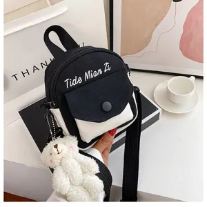 Detailed view of casual canvas crossbody bag, black and white design with cute bear pendant.