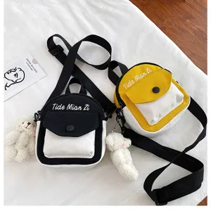 Canvas small crossbody bag with cute bear pendant, trendy color block design for daily use.