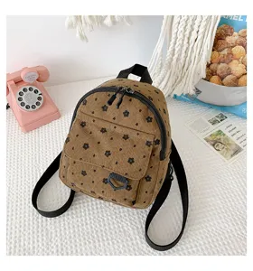 Detailansicht eines kleinen Kord-Rucksacks mit Blumenmuster und lässigem Alltagsstil.