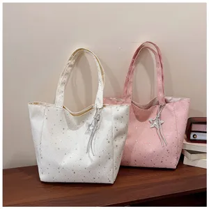 Close-up of star print tote bag detail showing off-white and pink colors with cute star charm.