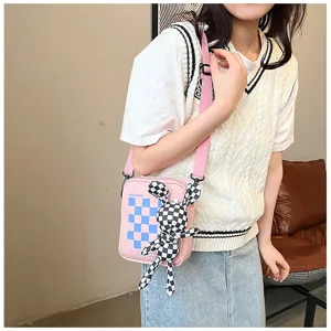 Cute pink canvas crossbody bag with trendy checkered pattern and cute bunny plush pendant.