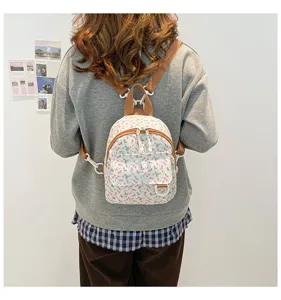 Back view detail shot of a cute floral mini backpack worn by model, showing casual style.