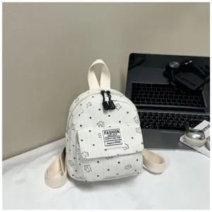 Detailed view of a cute mini corduroy backpack with floral print, front pocket and zipper.