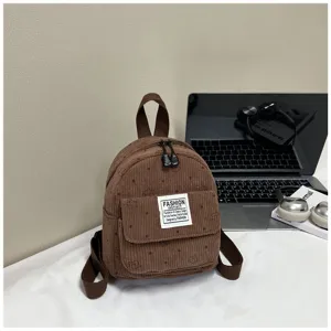 Brown corduroy mini backpack with front pocket and shoulder straps, detailed design view.