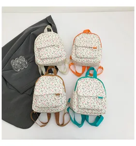 Detailed view of sweet floral mini backpacks in four color variants with front accessory pockets.