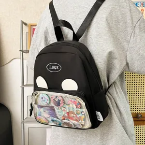 Scatto dettagliato di uno zaino nero con tasca frontale trasparente e spille anime.