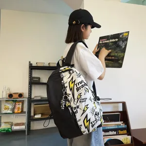 Stylish black and white color block student backpack with lightning print and cool astronaut keychain.