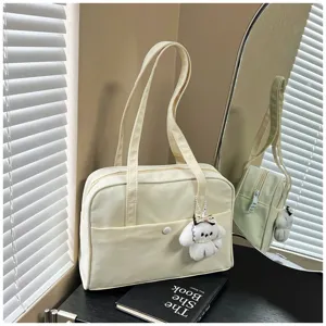 Detailed view of the casual solid color large capacity shoulder tote bag with a cute dog pendant.