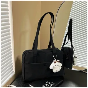 Black casual commuter tote bag detail with large capacity, sturdy handles and cute plush puppy charm.