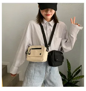 Vista dettagliata della borsa a tracolla in tela casual indossata dal modello con tasche zip.
