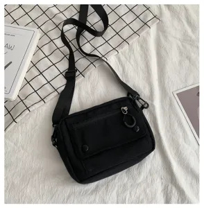 Borsa a tracolla in tela nera dettaglio, borsa casual con cerniera e tasca frontale.