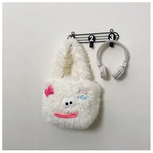 Close-up detail of the cute white plush tote bag featuring funny 3D eyes and pink bow on wall.