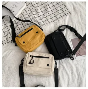 Borsa a tracolla casual in tela con tasca frontale e patta, ideale per la scuola e l'uso quotidiano.