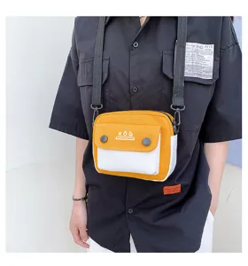 Detail view of yellow and white canvas crossbody bag with contrast flap and shoulder strap.