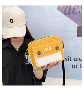 Canvas crossbody bag detail showing yellow and white color block design with front pocket.