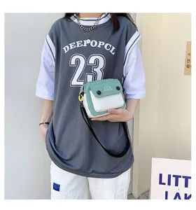 Green and white canvas crossbody bag showcasing detailed front pocket and strap design